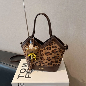 Chic leopard print bucket bag with brown leather trim and a cute plush bear charm