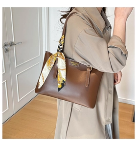 Detail of dark brown tote bag with vintage scarf tied to the handle for modern styling