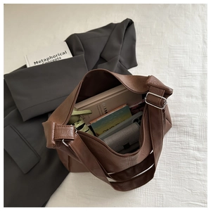 Vue intérieure du grand sac cabas marron foncé montrant le rangement pour livres et portefeuille