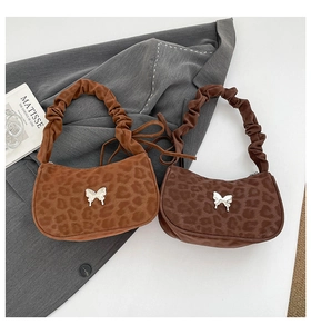 Gros plan détaillé de sacs léopard avec breloque papillon et poignées plissées chic