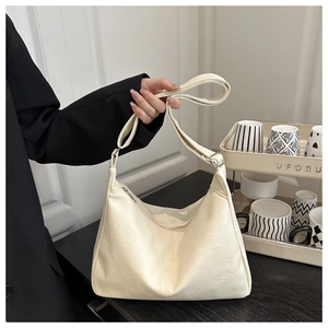Détail du sac hobo minimaliste crème avec large bandoulière et boucle en métal argenté