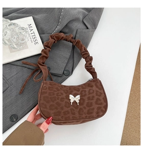 Détail du sac à bandoulière léopard avec papillon argenté et bandoulière froncée