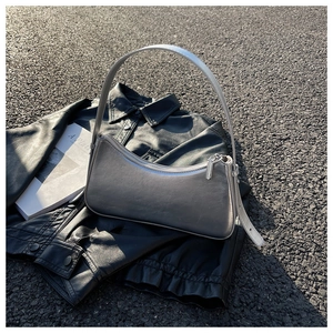 Detail shot of a shiny silver hobo shoulder bag with a sleek metallic finish texture