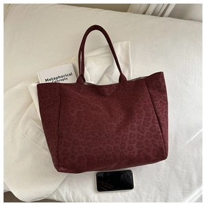 Macro view of burgundy leopard print tote bag texture and large storage capacity
