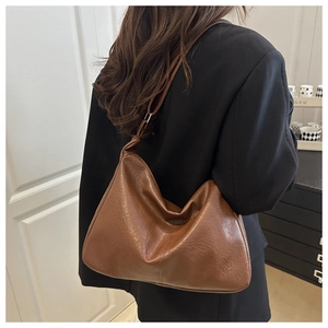 Gros plan d'un sac hobo marron vintage avec texture plissée et boucle en métal