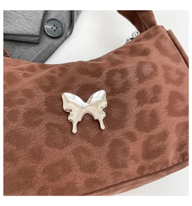 Détail du motif léopard et de la boucle papillon en métal argenté sur sac marron