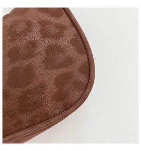 Gros plan sur la texture en daim imprimé léopard marron d'un sac à bandoulière chic
