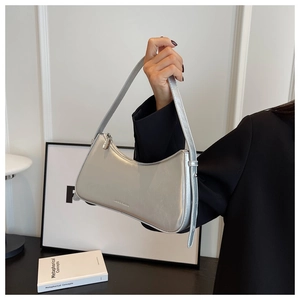 Detailed view of a metallic silver croissant bag featuring a smooth glossy finish