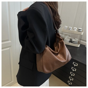 Gros plan du sac hobo marron caramel montrant la texture souple et la grande capacité