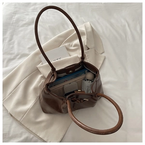 Interior detail of large brown faux leather tote showing spacious storage and magnetic closure