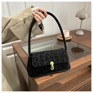 Close-up of leopard print shoulder bag with gold metal buckle and suede texture