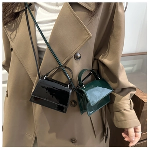 Detail of mini glossy square crossbody bags in black and dark green with top handles