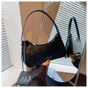 Detail of black pebbled leather underarm bag with silver zipper and logo reflection