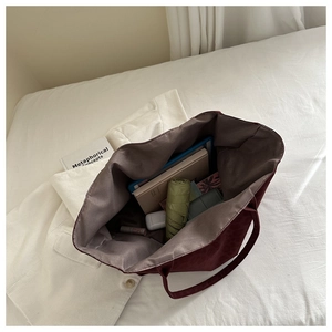 Spacious burgundy suede tote bag interior showing capacity for laptops and daily items
