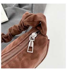 Gros plan détaillé d'un sac en daim marron avec fermeture éclair argentée et fronces