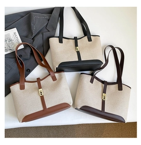 Detail shot of multi-color canvas tote bags with leather trim and metallic buckles