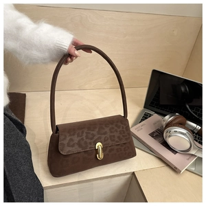 Brown suede crossbody bag featuring leopard print flap and golden metallic clasp detail