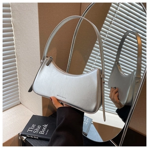 Detailed mirror reflection of a chic silver metallic hobo shoulder bag with a long strap