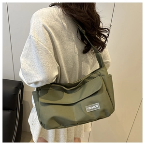 Rear view of an olive green nylon tote bag showing the large front pocket and strap