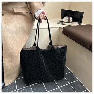 Detail of a large leopard print tote bag in soft fabric, ideal for office or daily commute