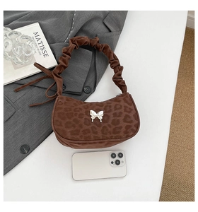 Détail du sac sous le bras à imprimé léopard avec boucle papillon et bandoulière froncée
