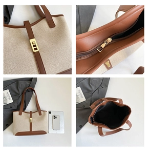 Detail view of canvas and leather tote showing metal buckle, stitching, and large capacity