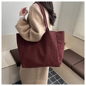 Leopard print burgundy tote bag shown on shoulder over a beige coat for autumn style
