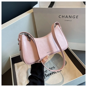 Detailed close-up of a pink crescent shoulder bag featuring a smooth leather texture