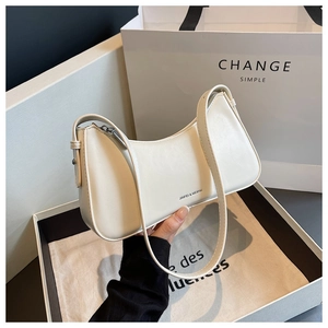 Detail of creamy white semi-circle hobo bag featuring silver zipper and leather texture