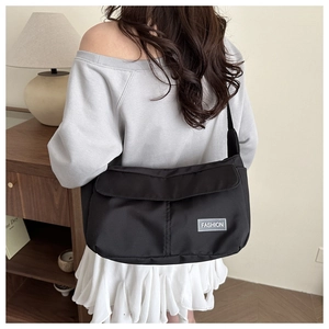 Dettaglio della borsa a tracolla in nylon nero leggero con etichetta moda su modella