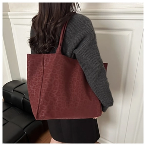 Detail showing the matte leopard print texture on this burgundy suede tote bag