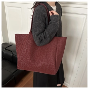 Close-up of a large burgundy leopard print tote bag in soft suede-like texture