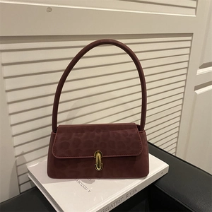 Chic burgundy leopard print baguette bag with gold metal buckle on a white book