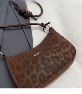 Detail of leopard print shoulder bag with Creative Cat text and round rope strap