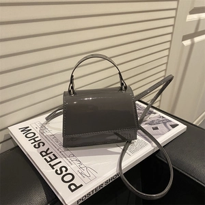 Minimalist dark grey patent leather square crossbody bag with glossy finish and top handle