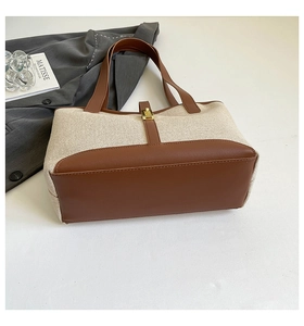 Detail of vintage tote bag with canvas stitching and elegant gold metal buckle closure