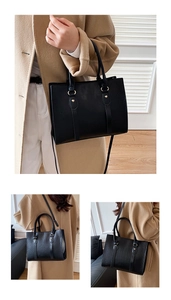 Macro detail of black crocodile pattern tote bag with gold ring hardware and dual straps