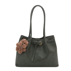 Minimalist dark green tote bag with decorative strap knot and plush dog charm accessory