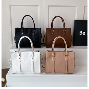 Detail view of four commuting tote bags in black, brown, white and beige faux crocodile leather