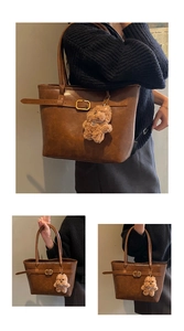 Detail of vintage brown tote bag with decorative strap, metal buckle and plush bear charm