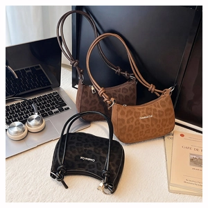 Chic leopard print shoulder bags styled with a laptop and books for a casual travel look