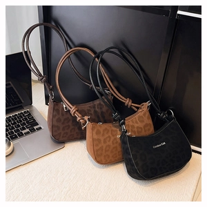 Detail view of leopard print crescent bags in three colors with knotted shoulder straps