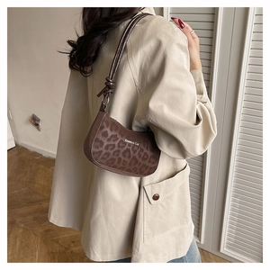 Detail of leopard print underarm bag with knot strap on a beige trench coat