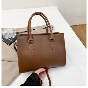 Detail showing high-quality brown PU leather texture and metal rings of the tote bag