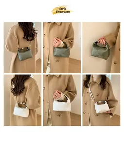 Minimalist square crossbody bag detail showing short handles and textured synthetic leather