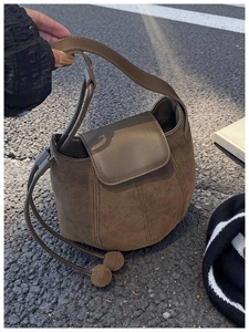 Gros plan d'un sac seau en daim marron avec détails de cordon de serrage décoratif