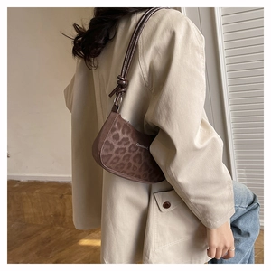Detail of trendy leopard print shoulder bag with crescent shape on casual outfit