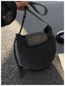 Détail du sac seau citrouille noir montrant le mélange de daim mat et de cuir brillant