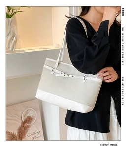 Détail du sac cabas tissé blanc cassé avec garniture en cuir lisse et boucles en métal