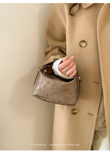 Detail showing the bronze pleated texture and metallic finish of this retro handbag